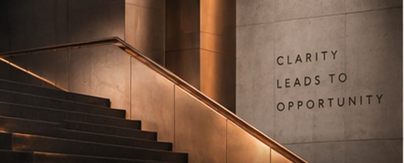 A staircase with the words Clarity Leads To Opportunity engraved on a wall