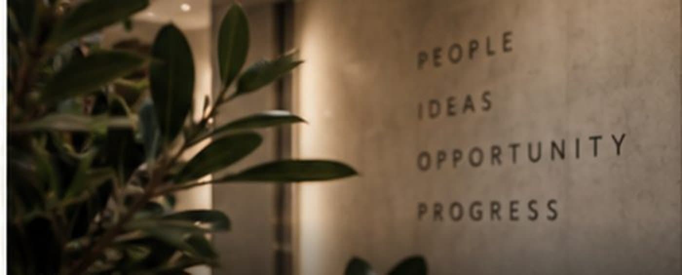 A wall reading People, Ideas, Opportunity, Progress